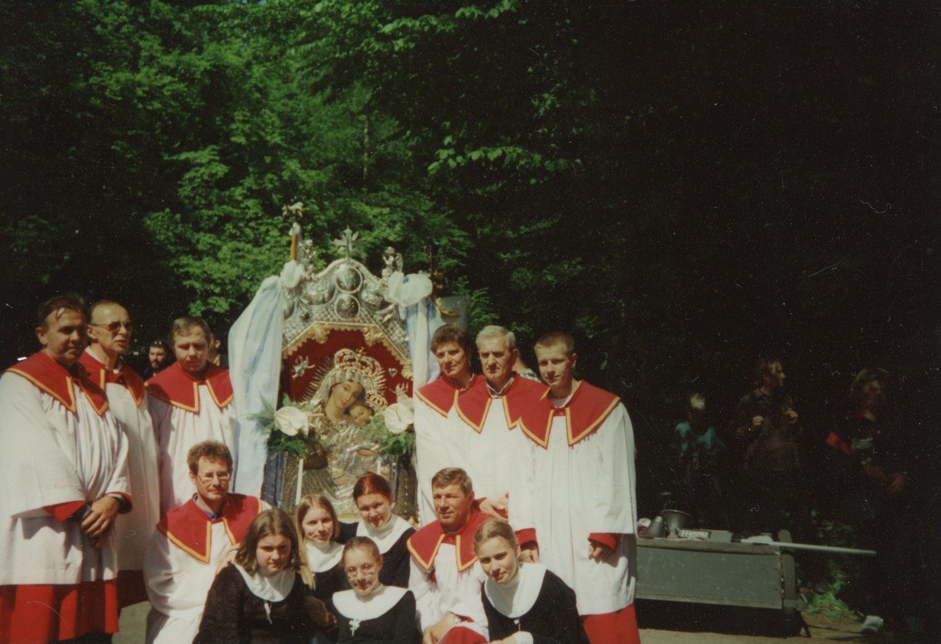 Pielgrzymka z Gdańska-Oliwy na Kalwarię Wejherowską. Lektorzy z feretronem oraz grupa dziewczyn z pielgrzymki pozują do zdjęcia.